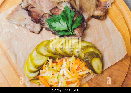 Composizione alimentare con insalata di manzo arrosto con pomodori secchi. Rucola, pomodoro e cetriolo su piatto bianco su fondo grigio. Vista dall'alto Foto Stock