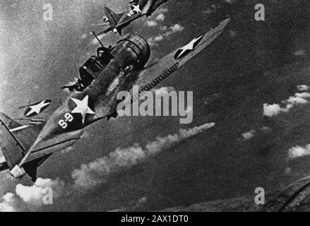 1942 , 6 GIUGNO , USA : BATTAGLIA INTERMEDIA . Combattenti della Marina durante l'attacco alla flotta giapponese al largo di Midway, da giugno 4th a 6th 1942. Al centro è visibile una nave giapponese in fiamme. (Navy) US Navy Douglas SBD-3 bomber da immersione "senza fine" da scouting squadron VS-8 dalla portaerei USS Hornet (CV-8) avvicinandosi all'incrociatore pesante giapponese che brucia MIKUMA per fare il terzo set di attacchi su di lei, durante la battaglia di Midway, 6 giugno 1942. Mikuma era stato colpito in precedenza da scioperi di Hornet e USS Enterprise (CV-6), lasciandola morta in acqua e fatalmente danneggiata. Nota bombe appese sotto t Foto Stock