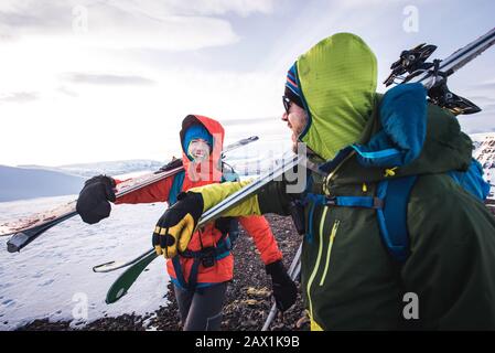 Donna e uomo ridono mentre camminano con gli sci in Islanda Foto Stock