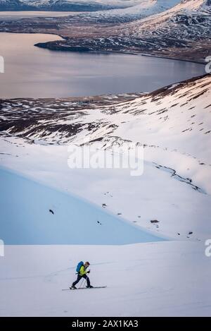 Uomo sci di fondo con acqua e oceano dietro in Islanda Foto Stock