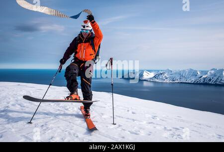 L'uomo tira via le pelli da sci mentre sci di fondo in Islanda Foto Stock