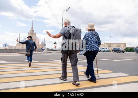 Russia Mosca 2019-06-17 Vecchia coppia che tiene le mani e cammina su attraversamento pedonale. Concetto attivo vecchiaia, hobby, viaggi, turisti invecchiati Foto Stock