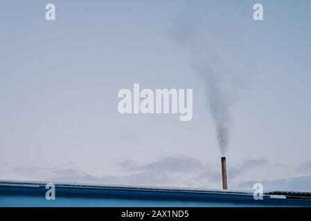 Emissione di fumo dalla fabbrica contro Sky Foto Stock