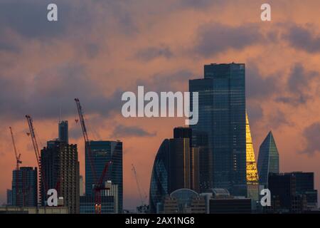 Londra, Regno Unito. 10th febbraio 2020. Città di Londra nuvole skyline che riflettono il tramonto dopo la tempesta Ciara, le gru di costruzione rimangono inattive a causa dei venti alti. Credito: Thamesfleet/Alamy Live News Foto Stock