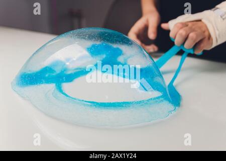 Kid Playing Hand Made Toy Chiamato Slime Alien drool Shell mitsel bambini mano in un cast Foto Stock