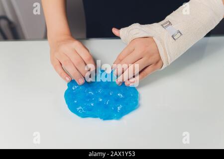 Kid Playing Hand Made Toy Chiamato Slime Alien drool Shell mitsel bambini mano in un cast Foto Stock