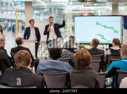 Pubblico ascolta docente al seminario Foto Stock