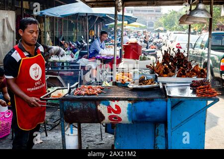 A Man Cooks Meat On Grill, Battambang, Cambogia. Foto Stock