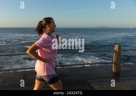 Jogger femmina che corre sul mare Foto Stock