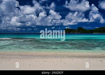 Takamaka Beach, Mahe Island, Seychelles - onde oceaniche e cielo. Foto Stock
