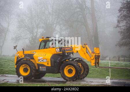 Denham, Regno Unito. 6 Febbraio 2020. Un carrello elevatore JCB 531-70 viene guidato attraverso una pista temporanea verso Denham Ford da un ingegnere che lavora per conto di HS2. I lavori previsti per il collegamento ferroviario ad alta velocità HS2 nelle immediate vicinanze includono la costruzione di un ponte Bailey attraverso il ford e di un complesso nel Denham Country Park che richiede la abbattimento di alberi antichi. Alcuni siti si trovano all'interno di una riserva naturale delle zone umide che fa parte di un sito di importanza metropolitana per la conservazione della natura (SMI). Credit: Mark Kerrison/Alamy Live News Foto Stock