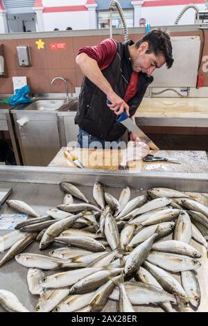 Uomo che prepara il pesce per la vendita sul mercato, Loule, Algarve, Portogallo Foto Stock