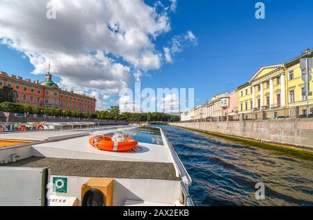 Una barca naviga sul fiume Neva con il Castello di San Michele, chiamato anche Castello Mikhailovsky, sulla sinistra a San Pietroburgo, Russia. Foto Stock
