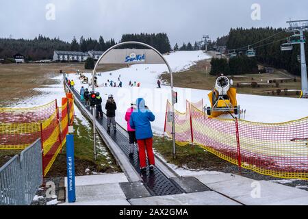 Skilift trasportatore a nastro, area sciistica per principianti Ritzhagen, gestito con neve artificiale, da cannoni da neve, Willingen, Sauerland, Hessen, Germania, Foto Stock