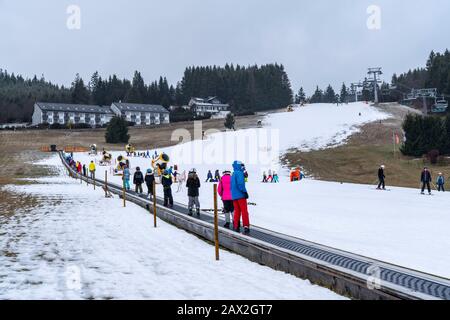 Skilift trasportatore a nastro, area sciistica per principianti Ritzhagen, gestito con neve artificiale, da cannoni da neve, Willingen, Sauerland, Hessen, Germania, Foto Stock