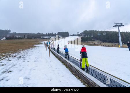 Skilift trasportatore a nastro, area sciistica per principianti Ritzhagen, gestito con neve artificiale, da cannoni da neve, Willingen, Sauerland, Hessen, Germania, Foto Stock