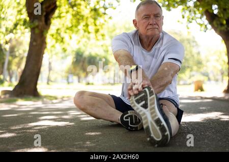 Stretching jogger nel parco Foto Stock