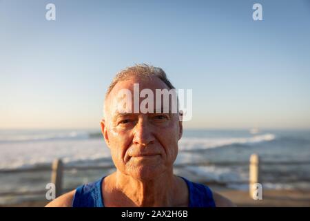 Jogger guardando la macchina fotografica sul mare Foto Stock