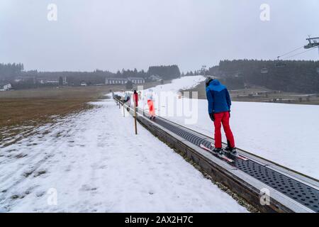 Skilift trasportatore a nastro, area sciistica per principianti Ritzhagen, gestito con neve artificiale, da cannoni da neve, Willingen, Sauerland, Hessen, Germania, Foto Stock