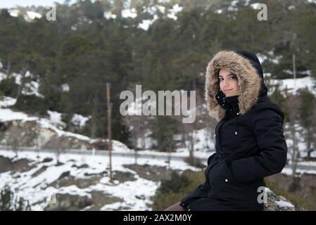 Ritratto di una giovane ragazza felice e bella teenage vestita di abbigliamento invernale in una montagna innevata. Troodos montagne Cipro Foto Stock