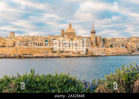 Valletta, lo skyline della città vecchia di Malta dalla città di Sliema sull'altro lato del porto durante l'alba Foto Stock