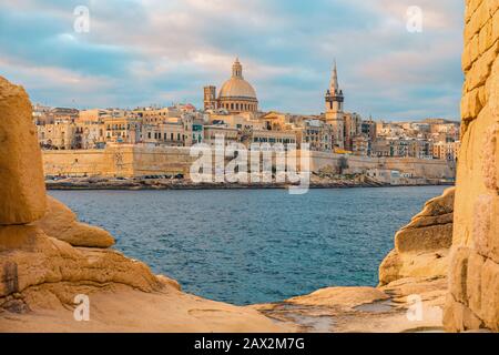 Vista sulla Valletta, lo skyline della città vecchia di Malta dalla città di Sliema sull'altro lato del porto di Marsans all'alba Foto Stock