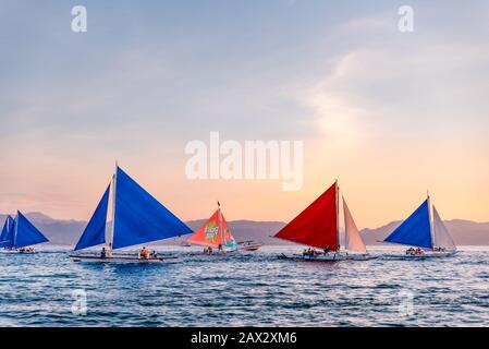 Isola di Boracay, Aklan, Filippine - I Visitatori godono del tramonto in una tradizionale barca a vela alimentata dal vento al tramonto. Circa Gennaio 2020. Foto Stock