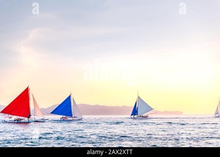 Isola di Boracay, Aklan, Filippine - I Visitatori godono del tramonto in una tradizionale barca a vela alimentata dal vento al tramonto. Circa Gennaio 2020. Foto Stock