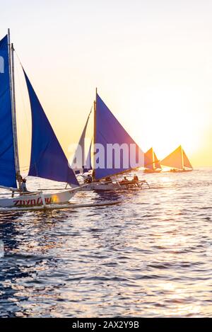 Isola di Boracay, Aklan, Filippine - I Visitatori godono del tramonto in una tradizionale barca a vela alimentata dal vento al tramonto. Circa Gennaio 2020. Foto Stock