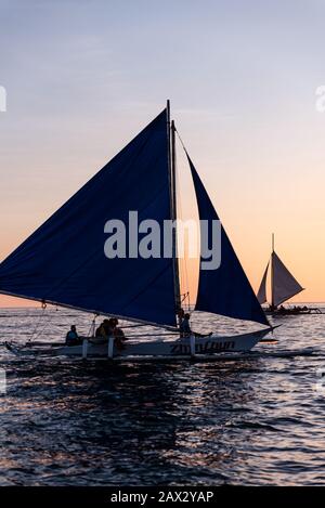 Isola di Boracay, Aklan, Filippine - I Visitatori godono del tramonto in una tradizionale barca a vela alimentata dal vento al tramonto. Circa Gennaio 2020. Foto Stock