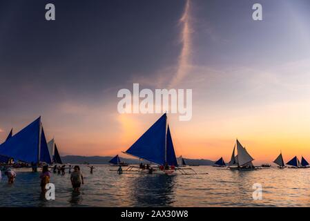 Isola di Boracay, Aklan, Filippine - I Visitatori godono del tramonto in una tradizionale barca a vela alimentata dal vento al tramonto. Circa Gennaio 2020. Foto Stock