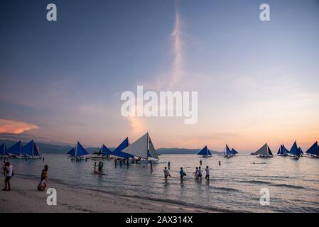 Isola di Boracay, Aklan, Filippine - I Visitatori godono del tramonto in una tradizionale barca a vela alimentata dal vento al tramonto. Circa Gennaio 2020. Foto Stock