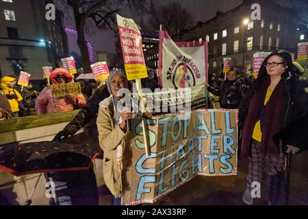 Londra, Regno Unito. 10th febbraio 2020. Il movimento per la Giustizia tiene una protesta di emergenza nel versare pioggia e venti alti a Downing St chiedendo un immediato termine per charter di deportazioni di massa di volo. Queste deportazioni strappano le famiglie, compreso molti dalle famiglie di Windrush, alcuni bambini, che hanno vissuto la maggior parte della loro vita nel Regno Unito e compreso la gente che ancora sta passando attraverso gli appelli con l'ufficio domestico. I manifestanti dicono che questi voli charter sono navi slave giorno moderno, con persone manacled mani, vita e piedi, ciascuno ammanettato in catene a due guardie con un terzo che li guarda. Peter Marsha Foto Stock