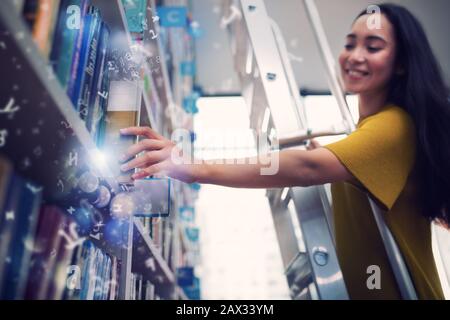 Ragazza scegliere un libro magico da leggere. Concetto di cultura, immaginazione e fantasia Foto Stock