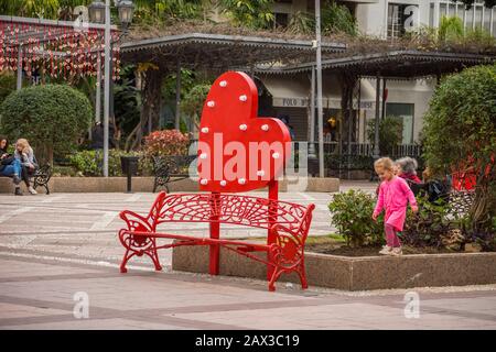 Decorazioni di San Valentino, panca rossa in una città spagnola, Fuengirola, Andalusia. Foto Stock