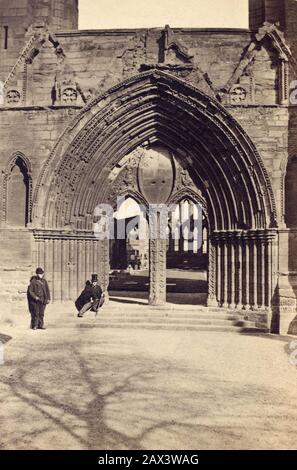 1865 ca , Elgin , Scozia , GRAN BRETAGNA : LA CATTEDRALE DI ELGIN , la porta Ovest ( l'ingresso postern ). Foto di H. Gordon , Aberdeen . Fondata nel 1224 , danneggiata dal fuoco nel 1270 e nel 1390, partigialli destituiti da un danno nel 1630 fu completamente abbandonata alla rovina e utilizzata come materiale riciclato per costruire altri edifici in città . - GRAND BRETAGNA - VIEW - SCOZIA - FOTO STORICHE - STORIA - GEOGRAFIA - GEOGRAFIA - ARCHITETTURA - ARCHITETTURA - STILE GOTICO - CATTEDRALE - CHIESA - CHIESA IN ROVINA - ROVINE - DIROCCATA - OTTOCENTO - '800 - TURISTI - TURISTA - TOURRI Foto Stock