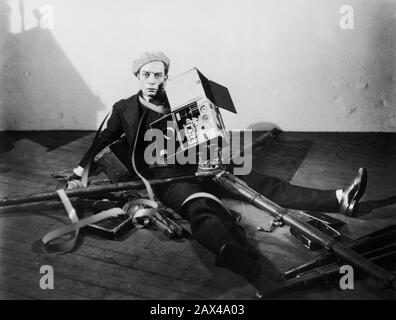 1928 , USA : l'attore e regista americano del cinema muto BUSTER KEATON ( 1895 - 1966 ) , in CAMERAMAN ( 1928 ) - SILENT MOVIE - CINEMA MUTO - ritratto - ritratto - registrazione filmato - attore - comico - COMICO - scarpe - cappello - CAPPELLO - ANNI TRENTA - 30 - fotocamera - macchina da presa - cavalletto - tripode - rullo - caduta accidentale - autunno - Falling - pellicola - film ---- ARCHIVIO GBB Foto Stock