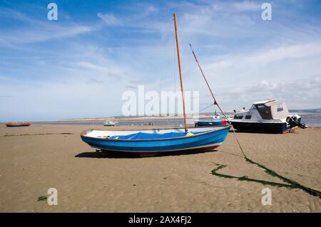 Barca a vela ormeggiata con un'ancora sulla spiaggia con bassa marea sulla spiaggia di Appledore North Devon Foto Stock