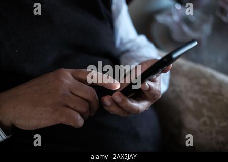 Primo piano di uomo anziano mano utilizzare smartphone Foto Stock