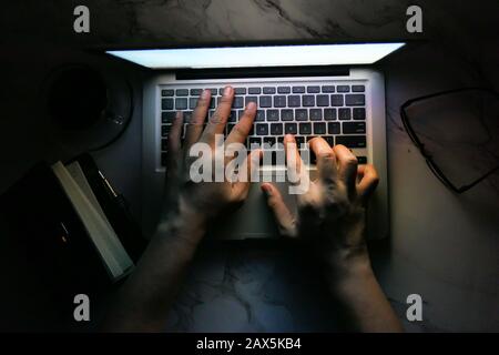 vista dall'alto della mano dell'uomo con il laptop a tarda notte Foto Stock