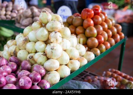 mucchio di pomodori e cipolla rossa e bianca nel mercato, piano generale Foto Stock