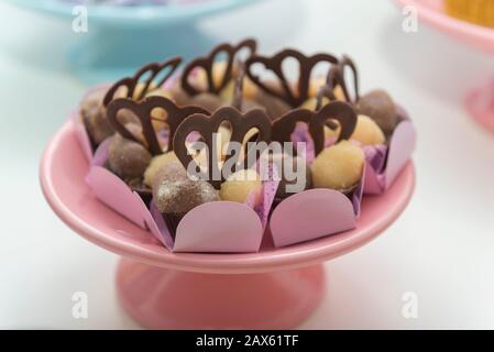 Caramelle al cioccolato di lusso in un vassoio vintage rosa caramelle al cioccolato bianco e scuro in festa di nozze. Delizioso, gustoso, dieta, concetto festivo. Selettivo f Foto Stock