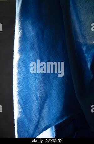 Astratto primo piano di stoffa blu appeso. Foto Stock