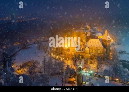 Budapest, Ungheria - veduta aerea del castello di Vajdahunyad innevato nel Parco cittadino con il grazioso mercato di Natale all'ora blu Foto Stock