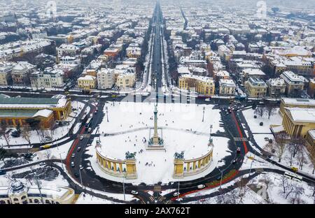 Budapest, Ungheria - veduta aerea dello skyline di Budapest nevosa con Piazza degli Eroi, via Andrassy e pista di pattinaggio su ghiaccio in una fredda giornata invernale Foto Stock