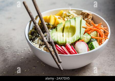 Ciotola vegan poke con avocado, tofu, riso, alghe, carote e manga. Concetto di cibo vegano. Foto Stock