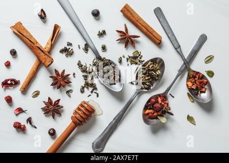 Diverso tè alle erbe con miele e spezie su sfondo bianco. Foto Stock