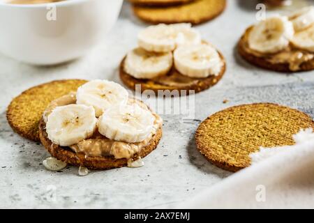 Burro di arachidi, cracker di banana e miele. Concetto di cibo vegano. Foto Stock