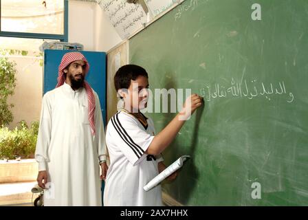 Insegnante di religione con studente in una scuola a Riyadh, Arabia Saudita. Foto Stock