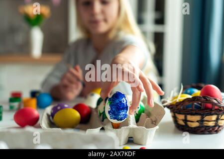 La mano femmina di closeup tiene un uovo blu. Focus sulle uova. Preparazione a Pasqua Foto Stock